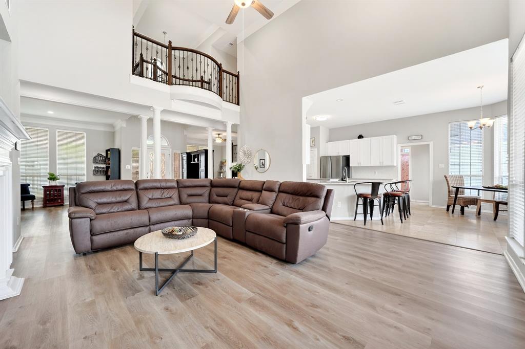 4509 Scenic Drive Rowlett, TX 75088 - Photo 18 of 40 Spacious living area featuring high ceilings, wood-finish flooring, and an upper-level balcony with a wrought iron railing