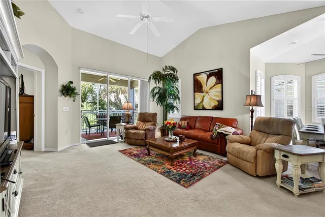 a blue couch sitting in a living room next to a potted plant