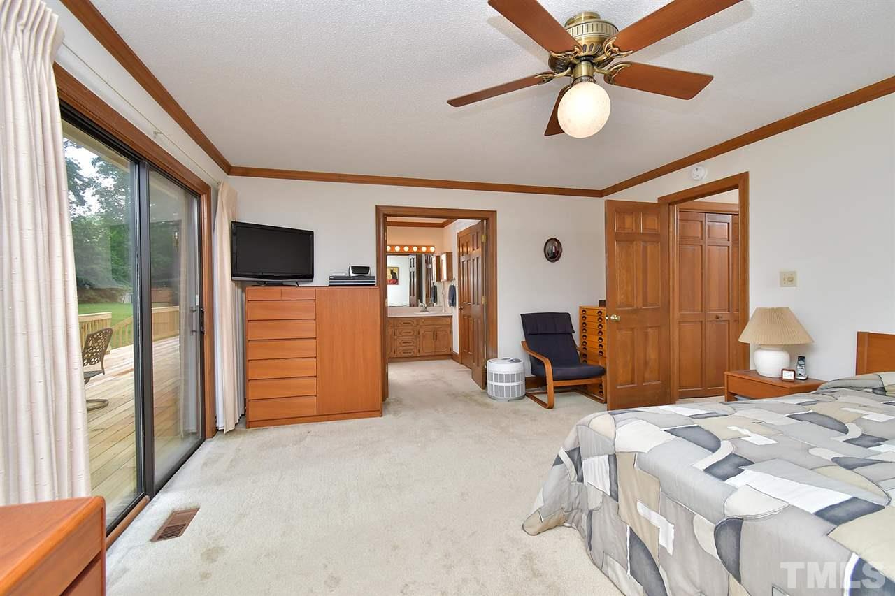 9437 Springdale Drive Raleigh, NC 27613 - Photo 11 of 30 a bedroom with a bed and a chandelier