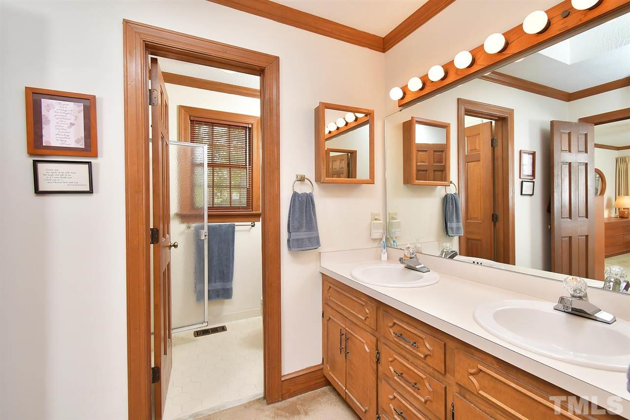 9437 Springdale Drive Raleigh, NC 27613 - Photo 12 of 30 a bathroom with a double vanity sink and a mirror
