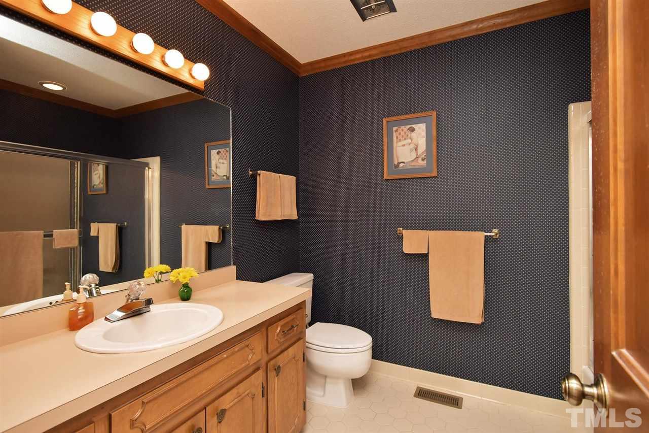 9437 Springdale Drive Raleigh, NC 27613 - Photo 13 of 30 a bathroom with a toilet a sink and mirror