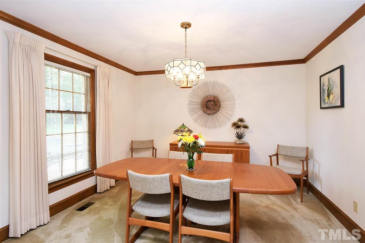 9437 Springdale Drive Raleigh, NC 27613 - Photo 18 of 30 a dining room with furniture a chandelier and window