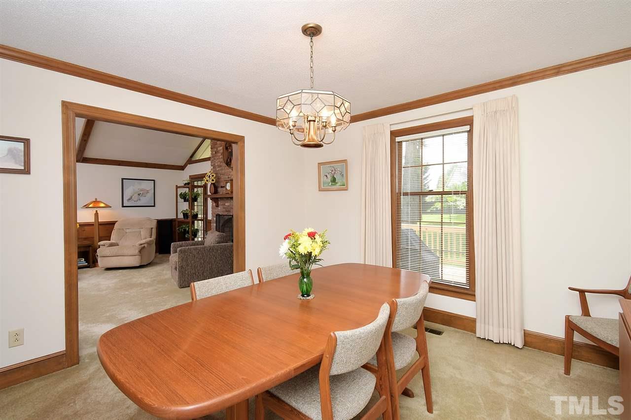 9437 Springdale Drive Raleigh, NC 27613 - Photo 19 of 30 a dining room with furniture a chandelier and window