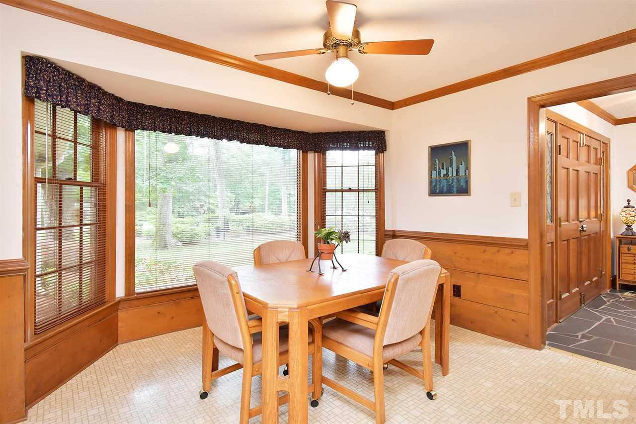 9437 Springdale Drive Raleigh, NC 27613 - Photo 22 of 30 a dining room with furniture a chandelier and wooden floor