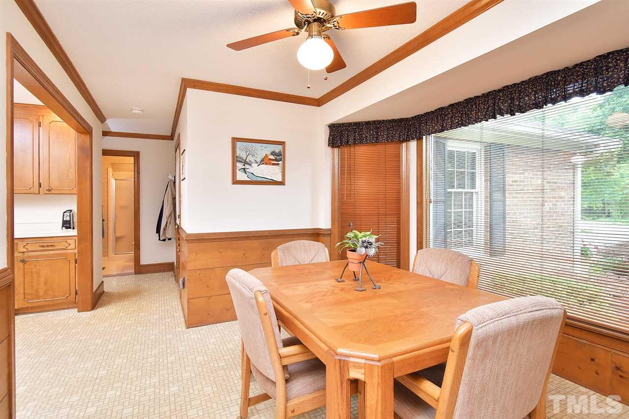 9437 Springdale Drive Raleigh, NC 27613 - Photo 23 of 30 a view of a dining room with furniture and a chandelier
