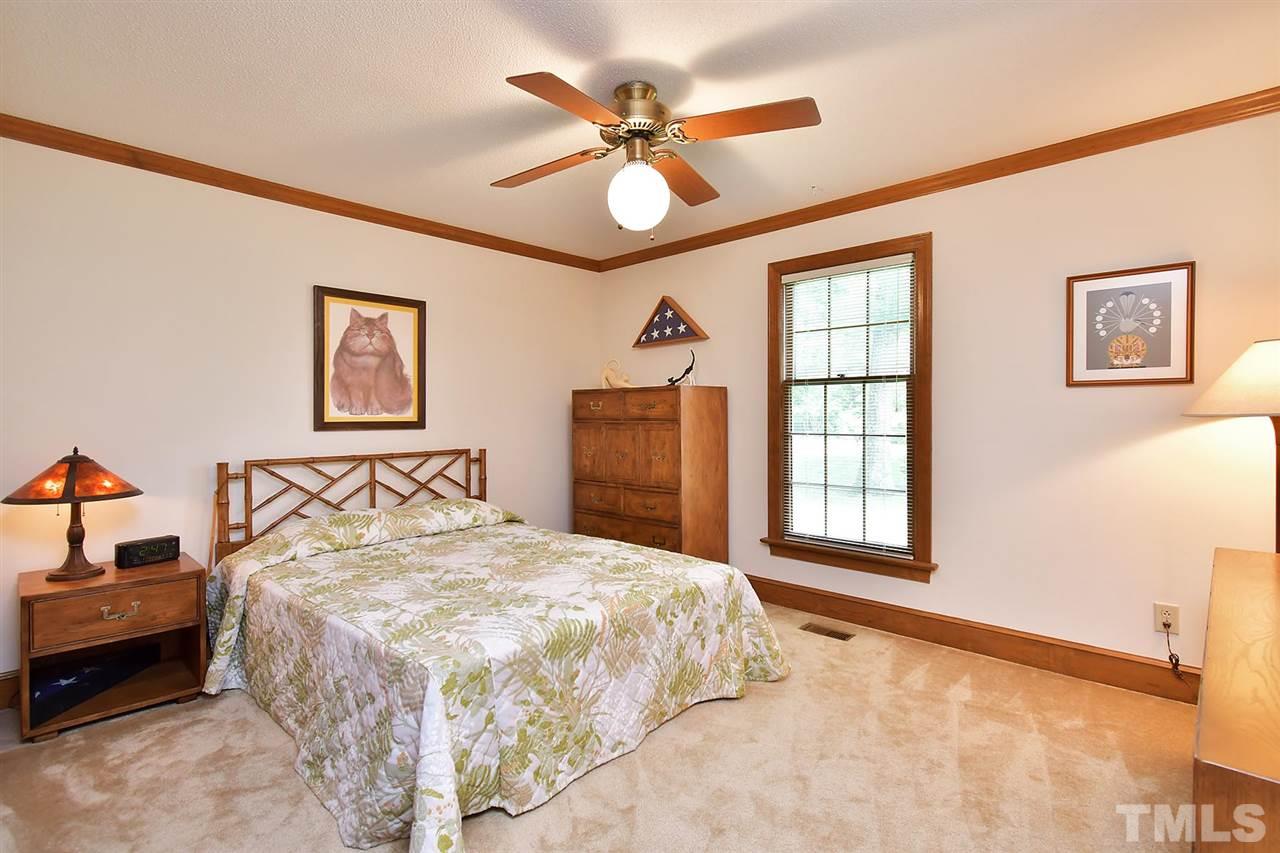 9437 Springdale Drive Raleigh, NC 27613 - Photo 8 of 30 a bedroom with a bed and a chandelier