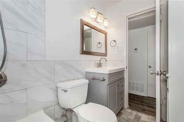 a bathroom with a toilet a sink and mirror