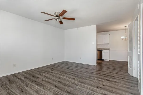 a view of empty room with wooden floor and ceiling fan