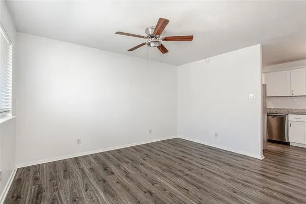 a view of a room with wooden floor and a ceiling fan