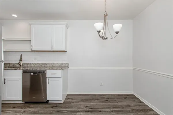 a view of a kitchen with cabinets and wooden floor