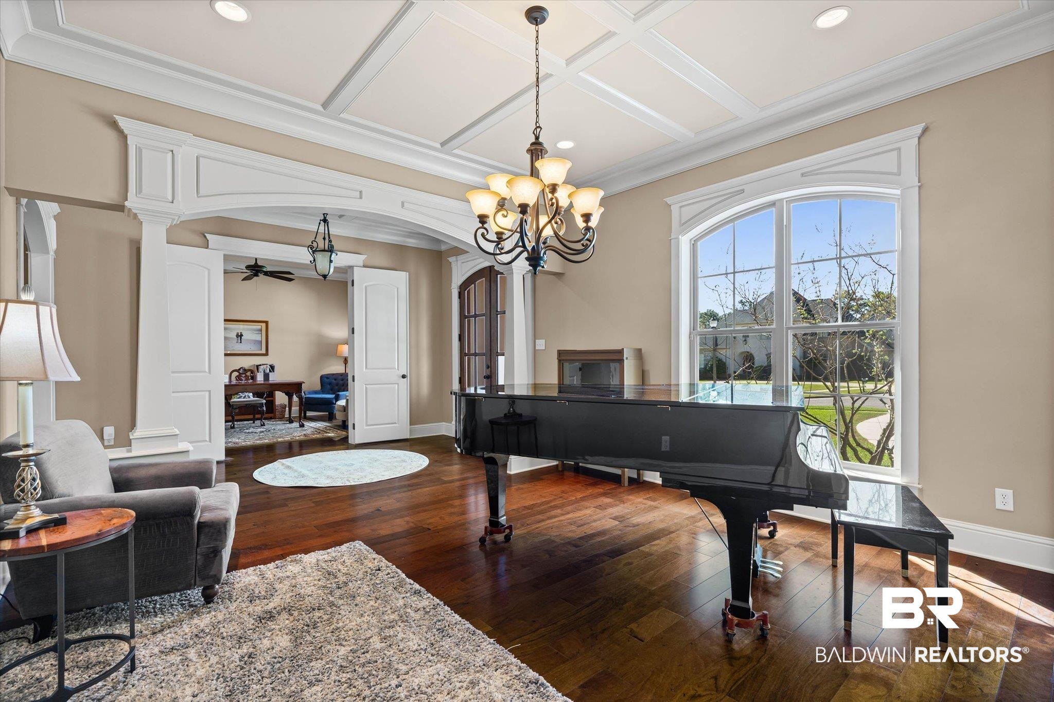 7676 Rockstone Lane Mobile, AL 36695 - Photo 5 of 47 Sitting room featuring coffered ceiling, dark wood-style flooring, arched walkways, crown molding, and a chandelier