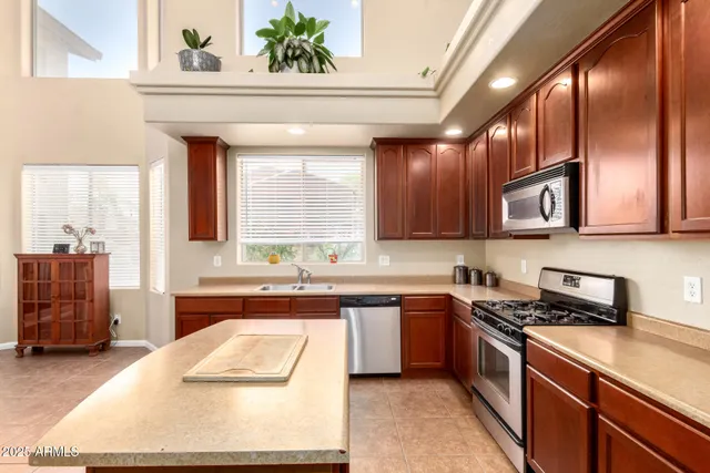 a kitchen with stainless steel appliances granite countertop a sink a stove and a refrigerator