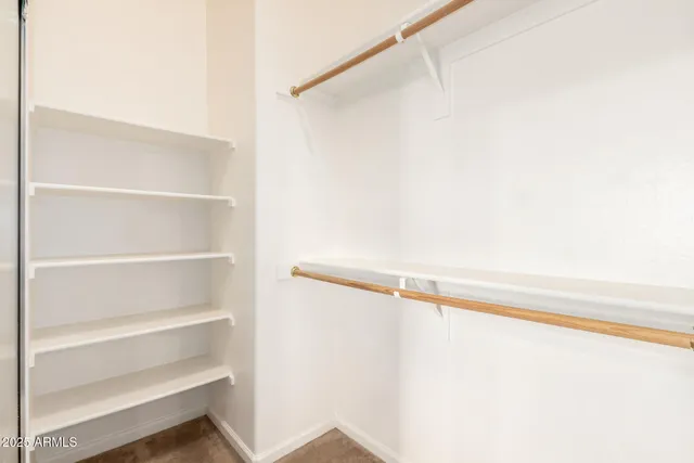 a bedroom with a bed chandelier and a window