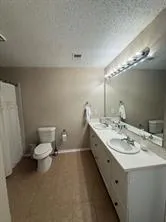 a bathroom with a double vanity sink and a toilet