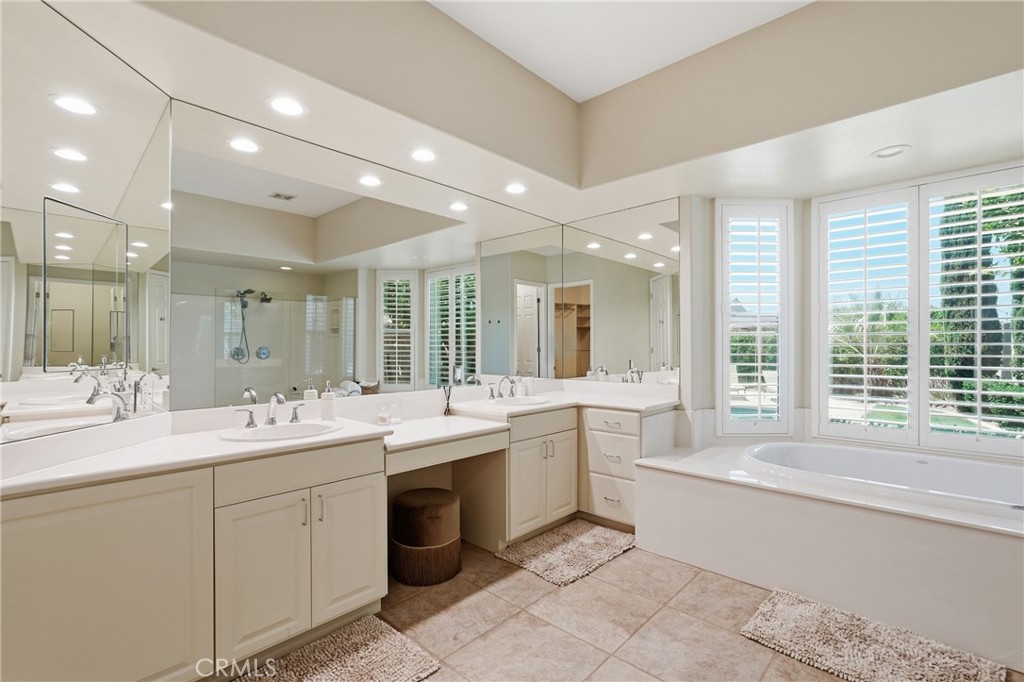 9 Orleans Road Rancho Mirage, CA 92270 - Photo 48 of 71 a large white bathroom with a large tub sink shower and mirror