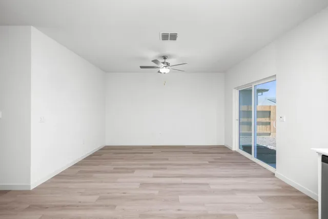 a view of a room with wooden floor and ceiling fan