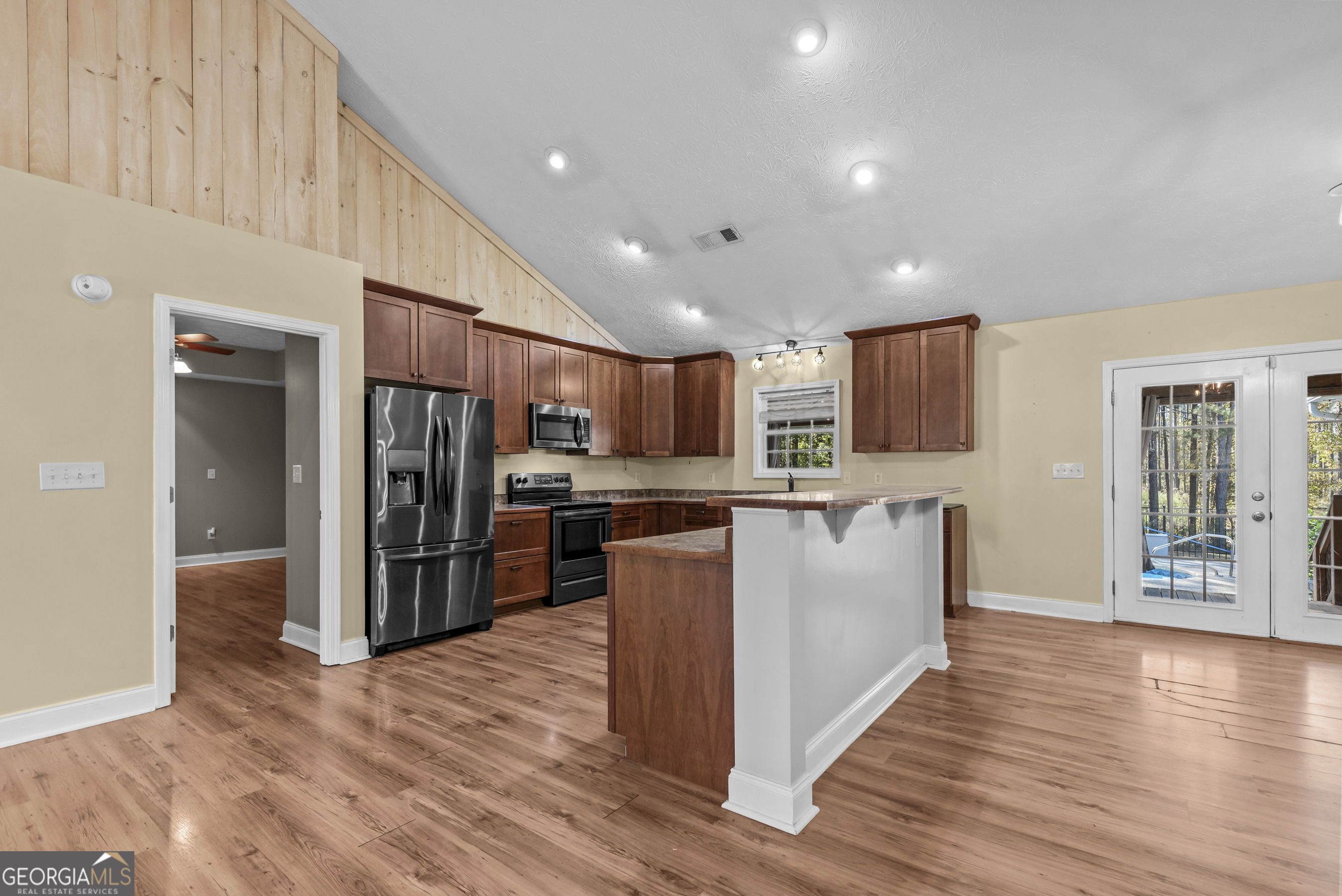 384 Scuffleboro Road Southeast Eatonton, GA 31024 - Photo 11 of 48 a kitchen with stainless steel appliances kitchen island wooden cabinets and granite counter tops