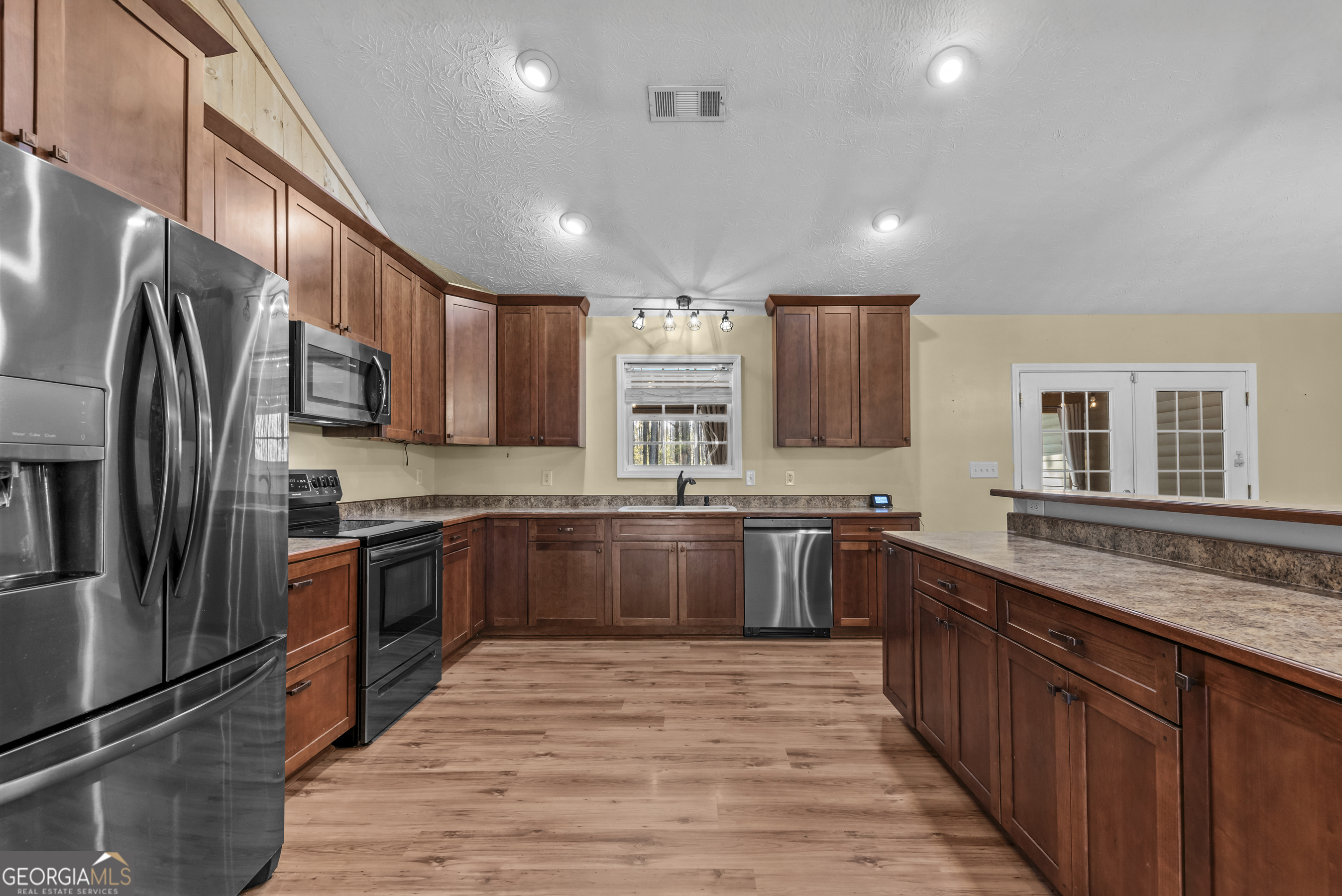 384 Scuffleboro Road Southeast Eatonton, GA 31024 - Photo 12 of 48 a large kitchen with stainless steel appliances granite countertop a stove sink refrigerator and cabinets