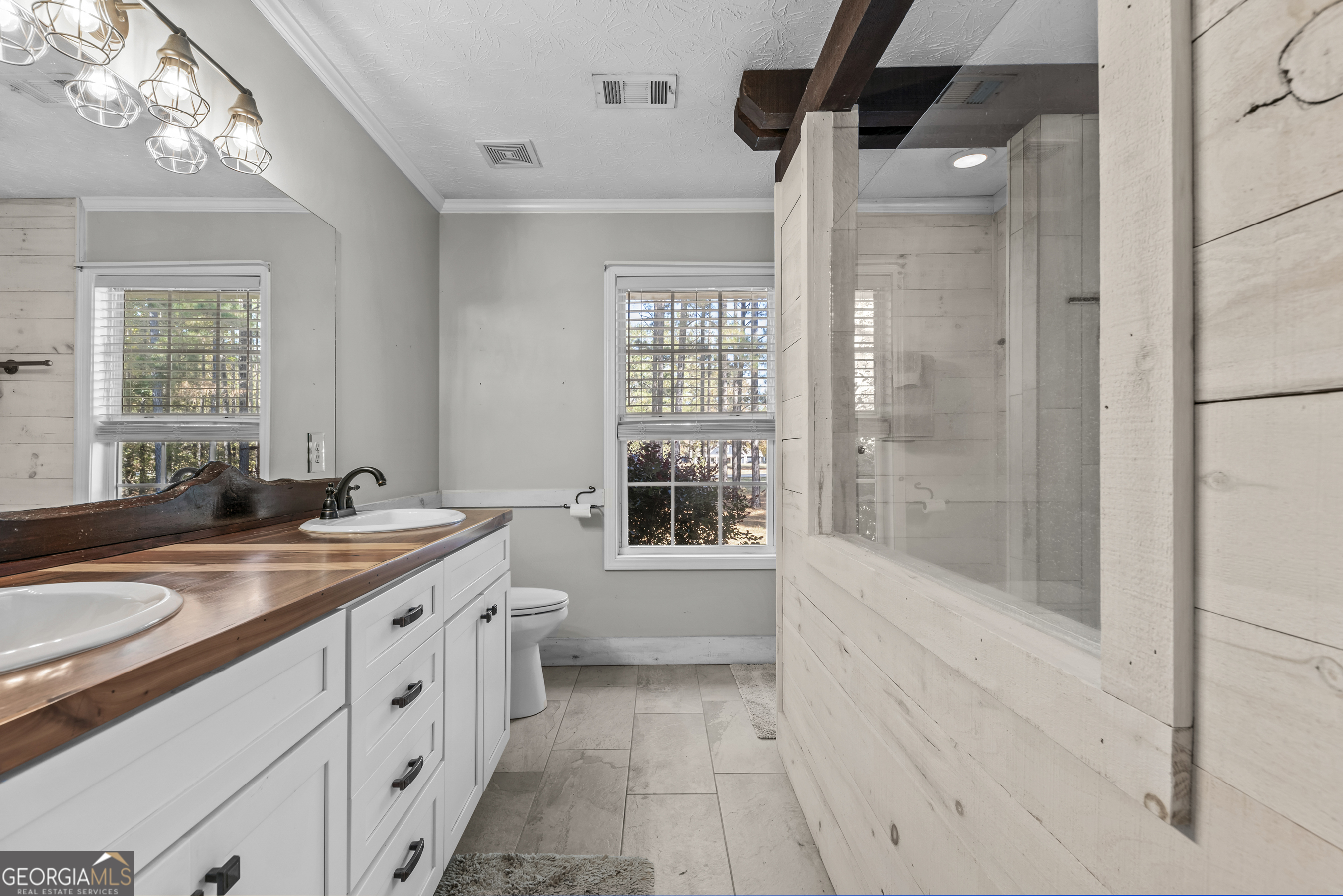 384 Scuffleboro Road Southeast Eatonton, GA 31024 - Photo 20 of 48 a bathroom with a sink a large mirror and a shower