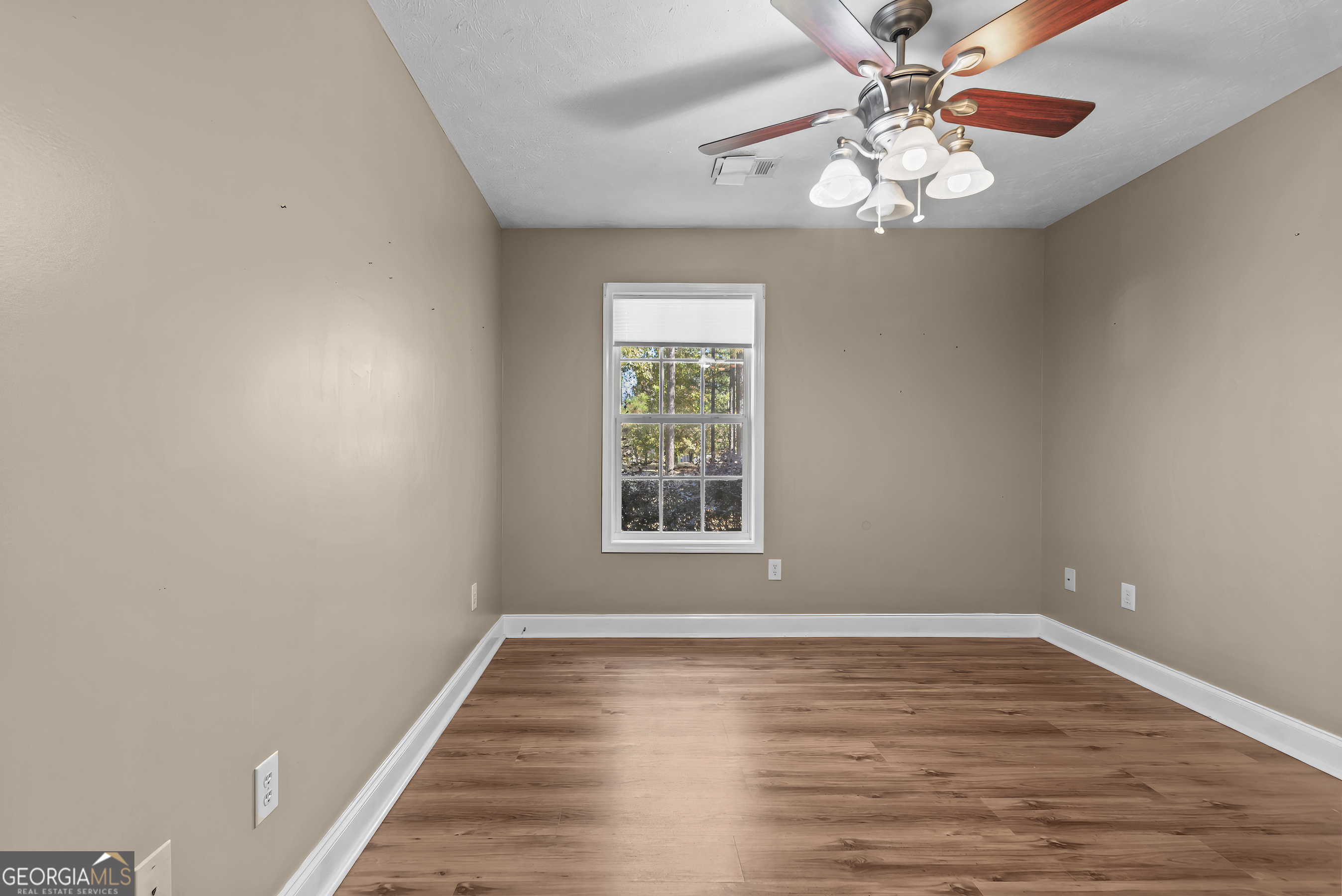 384 Scuffleboro Road Southeast Eatonton, GA 31024 - Photo 24 of 48 a view of an empty room with wooden floor and a window