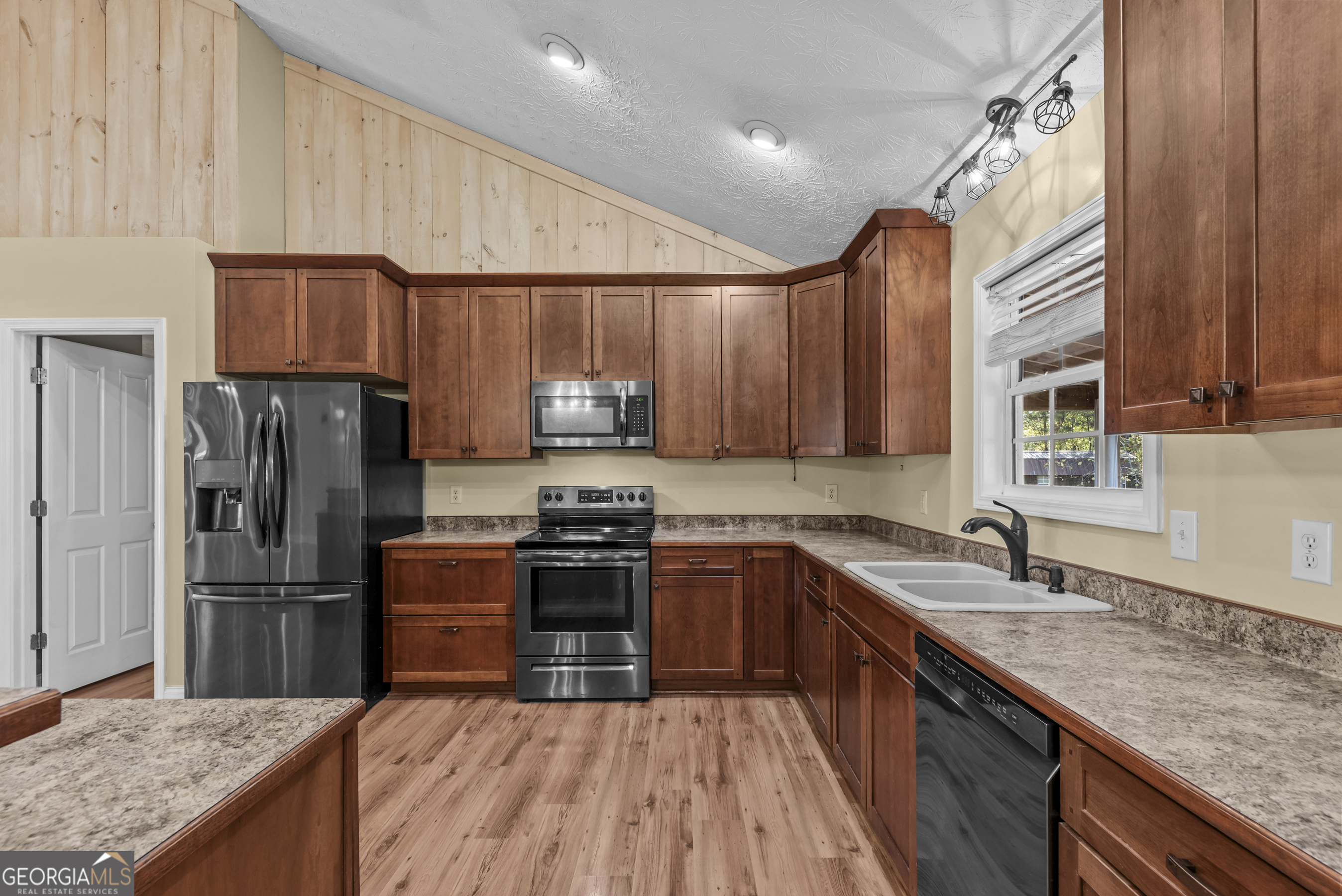 384 Scuffleboro Road Southeast Eatonton, GA 31024 - Photo 9 of 48 a kitchen with granite countertop wooden cabinets a stove top oven and stainless steel appliances