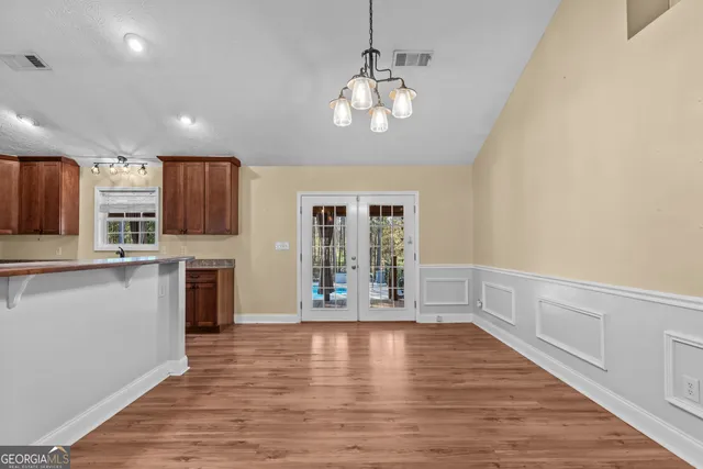 a view of a kitchen with a stove wooden cabinets and wooden floor