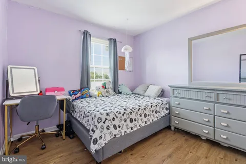 a bedroom with a bed chair and dresser