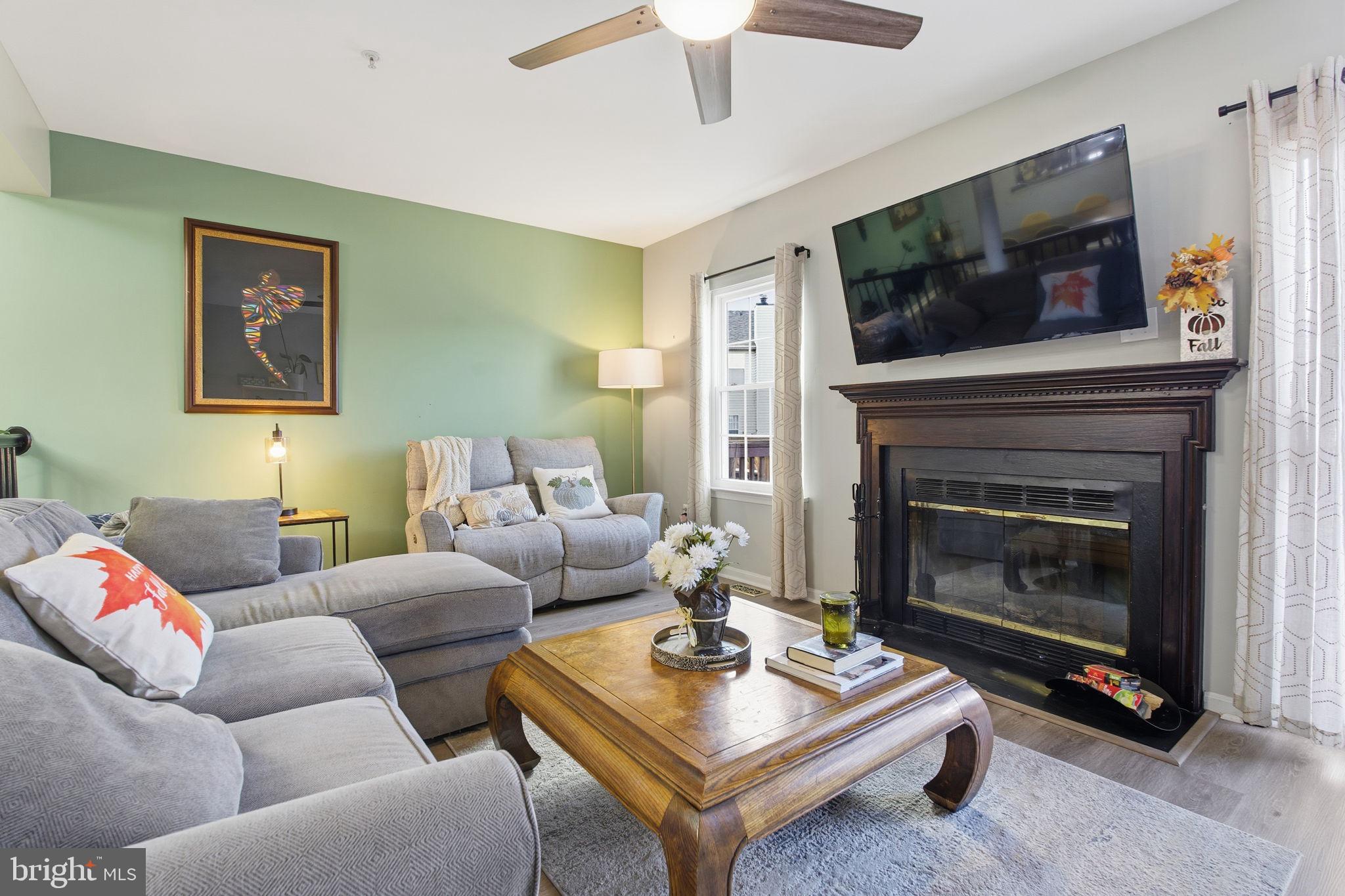 9300 Ridings Way Laurel, MD 20723 - Photo 3 of 24 a living room with furniture a flat screen tv and a fireplace