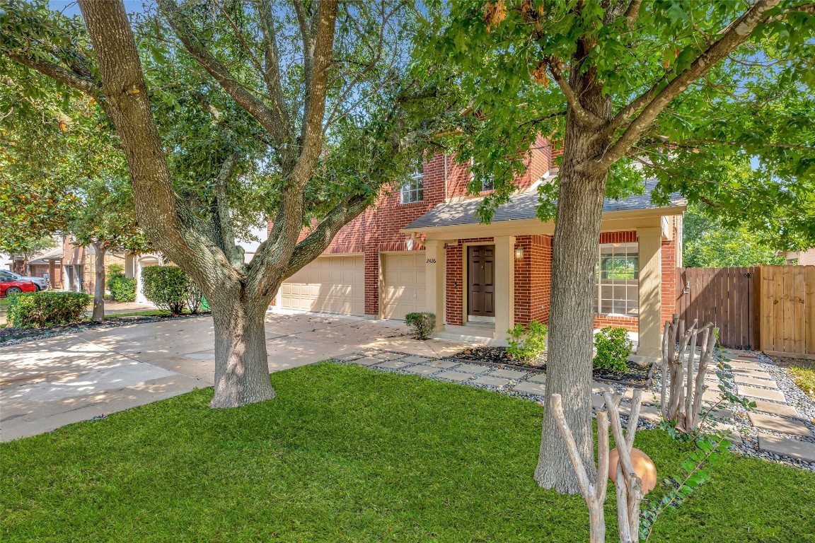 a white house that has tree in front of a yard