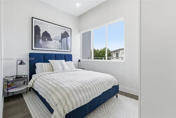 a bedroom with a bed and a painting on the wall