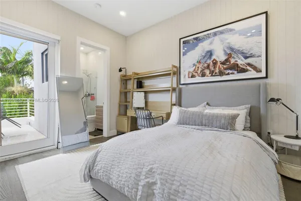 a bedroom with a large bed and a painting on the wall