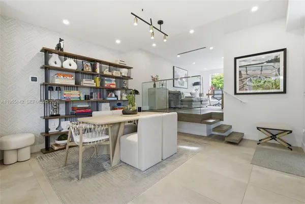 a room with stainless steel appliances furniture and a book shelf