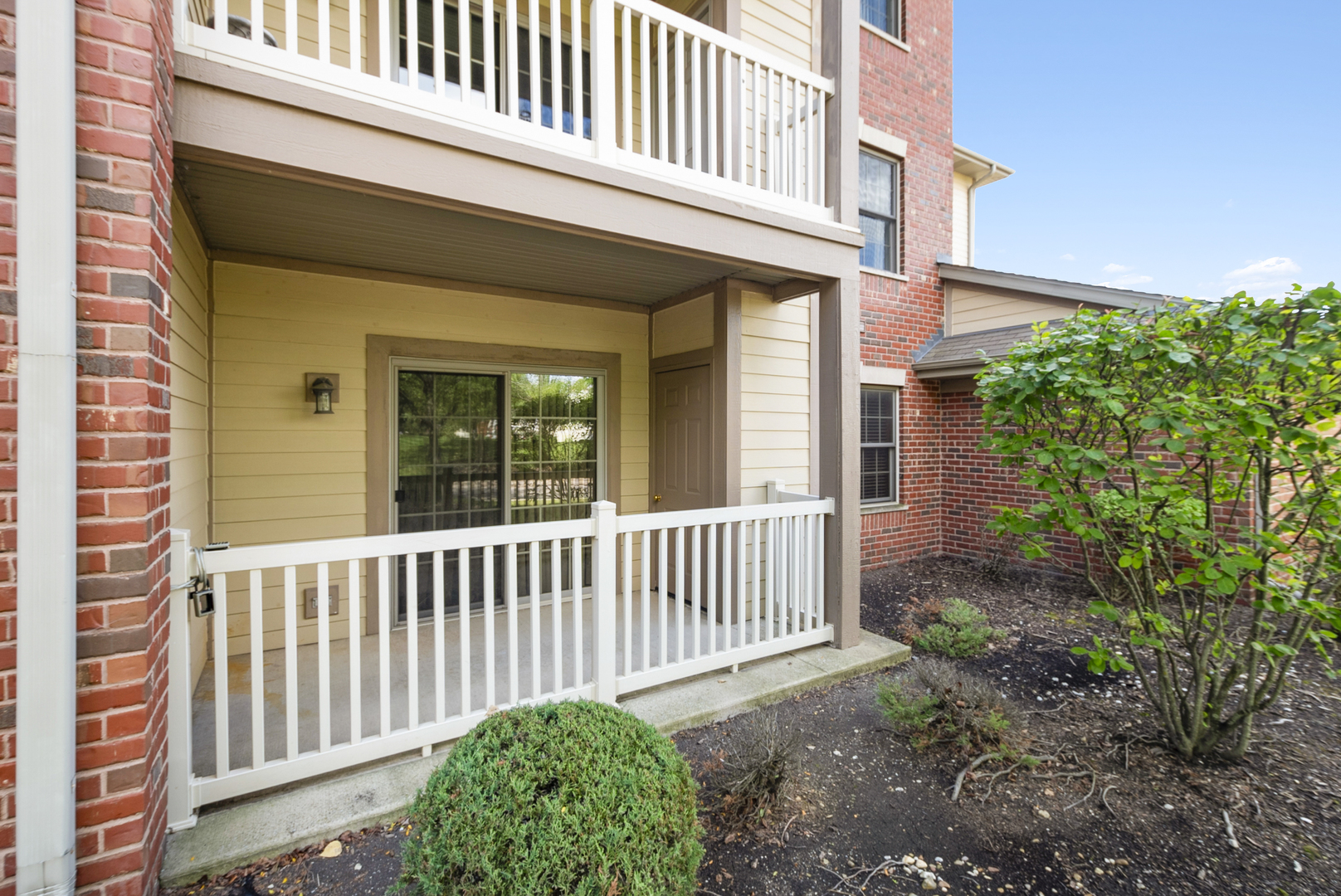 20301 South Pine Hill Road, Unit 1D Frankfort, IL 60423 - Photo 20 of 21 a view of a house with a small yard and floor to ceiling window and wooden fence