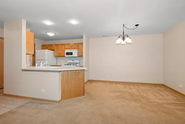 a view of kitchen with granite countertop cabinets and refrigerator