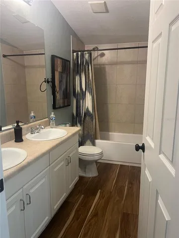 a bathroom with a double vanity sink toilet and shower