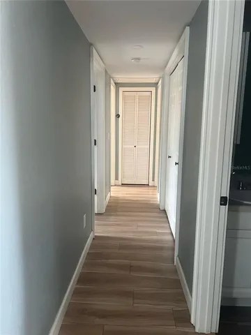 a view of a hallway with wooden floor and staircase