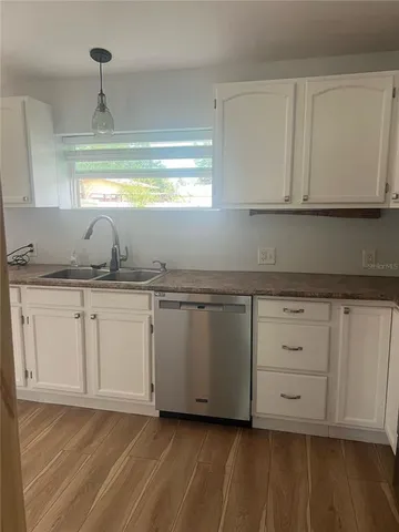 a kitchen with granite countertop white cabinets and a sink