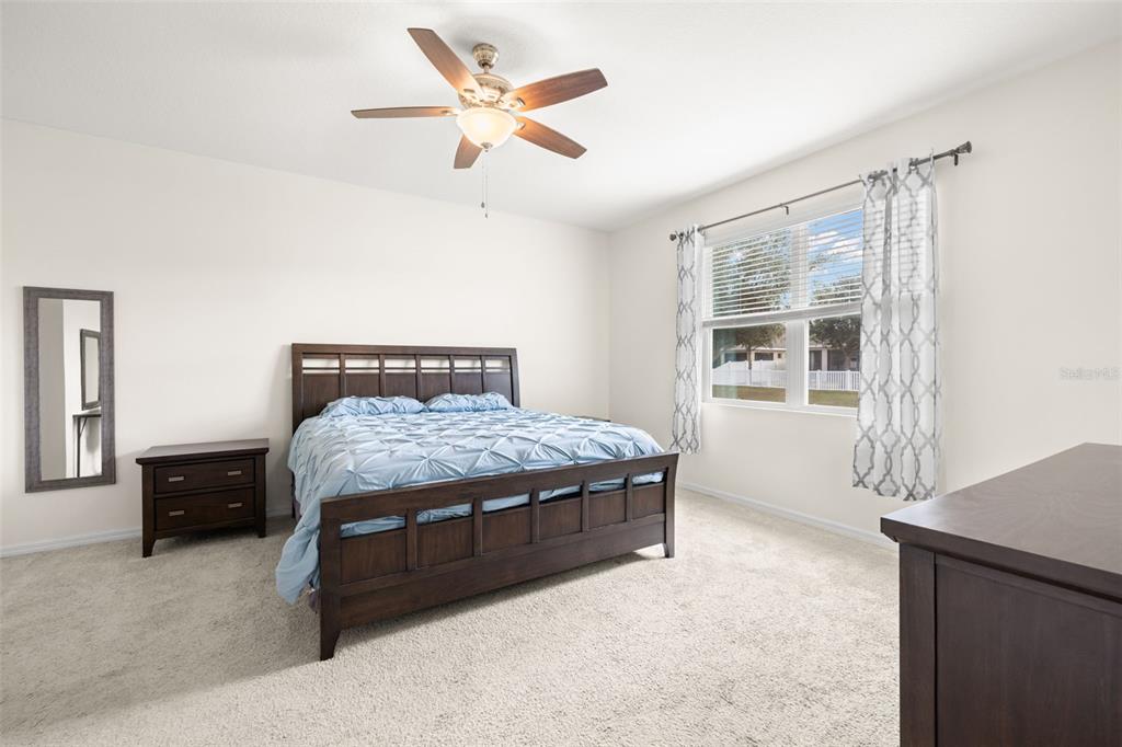 13562 Paddington Way Spring Hill, FL 34609 - Photo 14 of 39 a bedroom with a large bed and a window