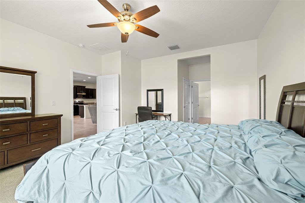 13562 Paddington Way Spring Hill, FL 34609 - Photo 15 of 39 a bedroom with a bed and a flat screen tv in it