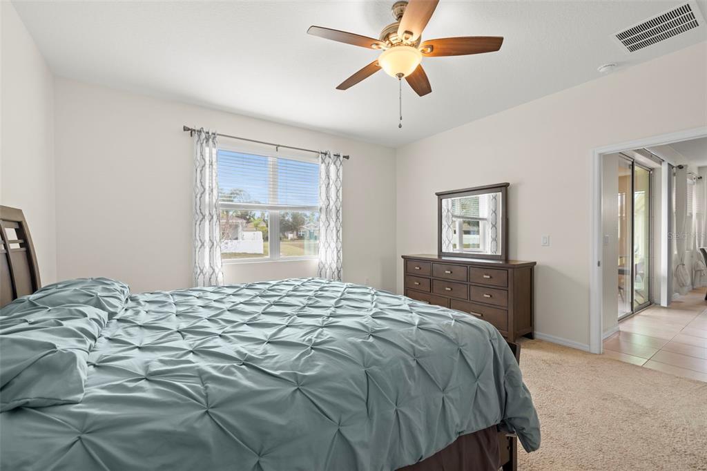 13562 Paddington Way Spring Hill, FL 34609 - Photo 16 of 39 a bedroom with a bed and a chandelier