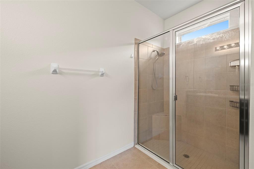 13562 Paddington Way Spring Hill, FL 34609 - Photo 20 of 39 a bathroom with a glass shower door