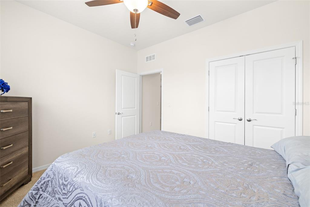 13562 Paddington Way Spring Hill, FL 34609 - Photo 23 of 39 a bedroom with a large bed and a chandelier fan