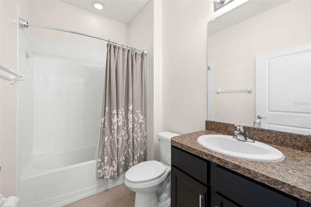 13562 Paddington Way Spring Hill, FL 34609 - Photo 24 of 39 a bathroom with a granite countertop sink toilet and shower
