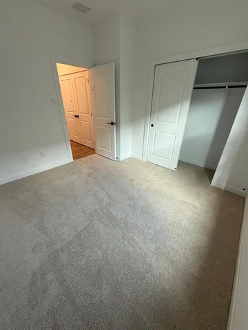 an empty room with closet and wooden door