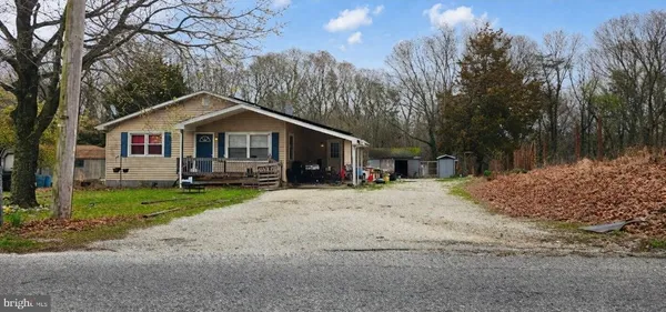 a front view of a house with a yard and trees