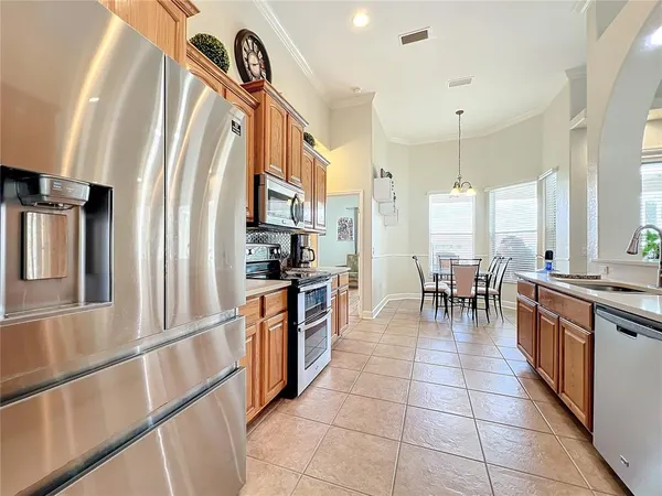 a kitchen with stainless steel appliances granite countertop a refrigerator a stove oven and a sink