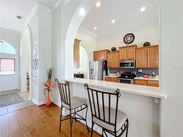 a kitchen with stainless steel appliances kitchen island granite countertop a refrigerator and microwave