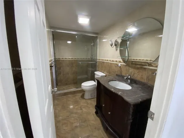 a bathroom with a double vanity sink toilet mirror and shower