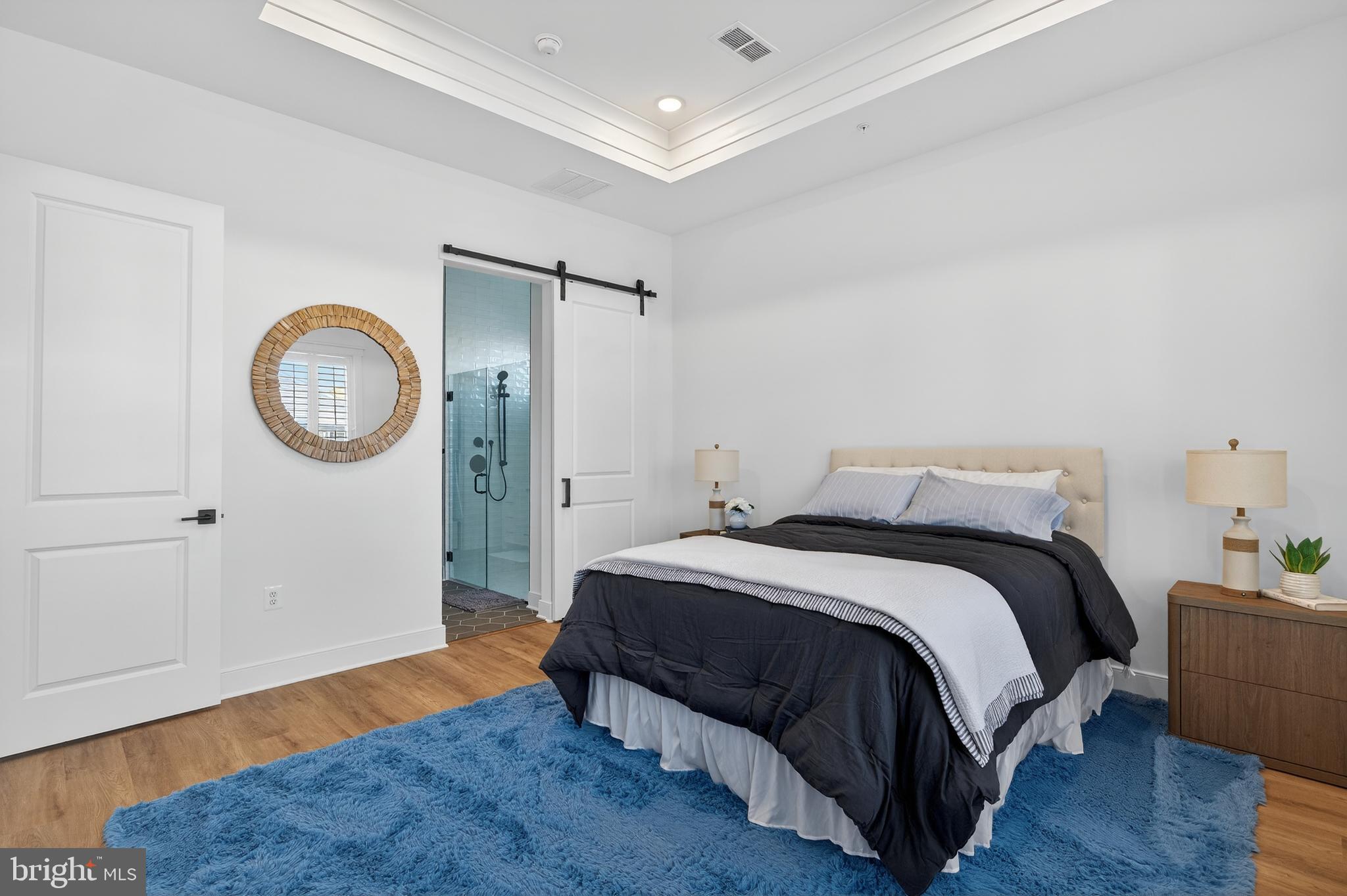 528 Warbler Way Chester, MD 21619 - Photo 13 of 29 a spacious bedroom with a bed a mirror and wooden floor