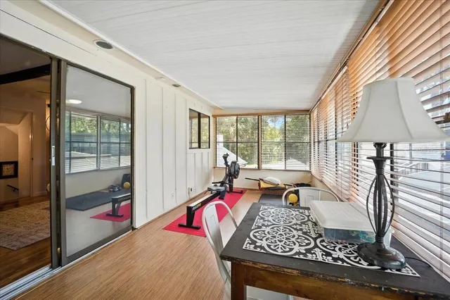 a dining room with furniture a chandelier and wooden floor